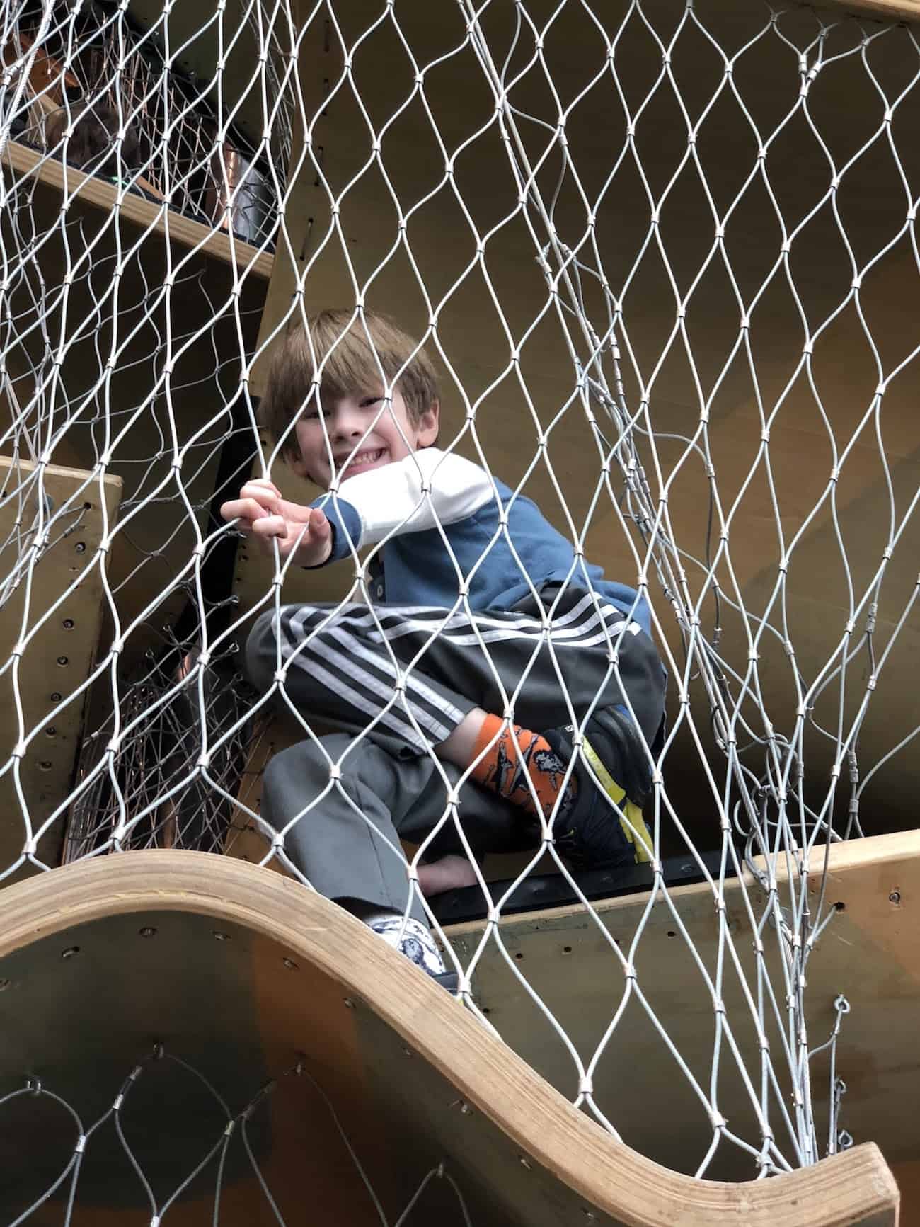 boy in climbing structure boston children's museum