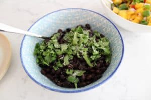 seasoned black beans in a bowl with a spoon