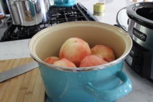 peeled peached in a teal stockpot