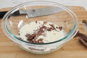 adding warm heavy cream to chocolate for ganache